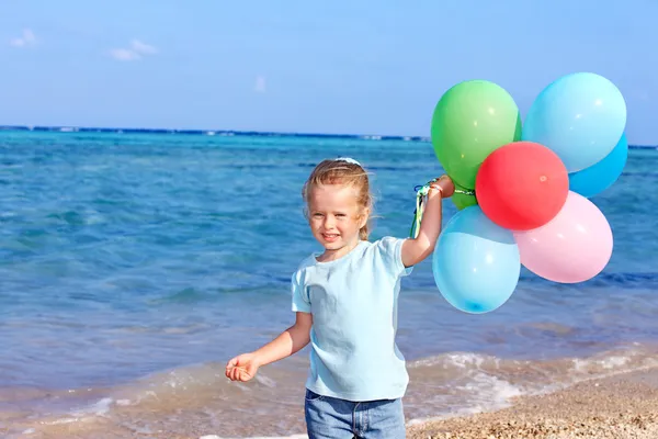Criança brincando com balões na praia — Fotografia de Stock