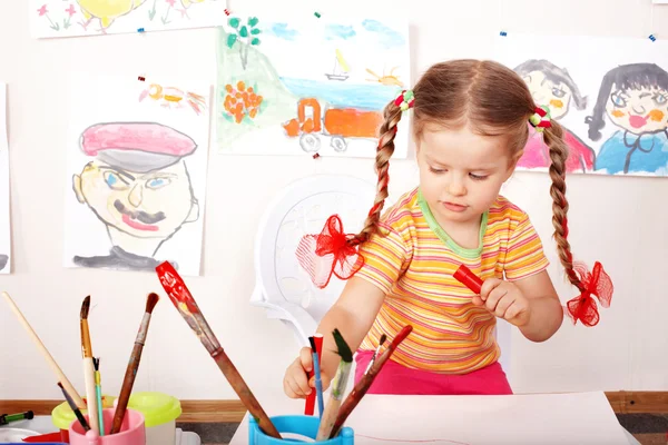 Kind met beeld en penseel in de speelkamer. — Stockfoto