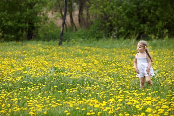 Kleines Mädchen auf Gras in Blume. — Stockfoto