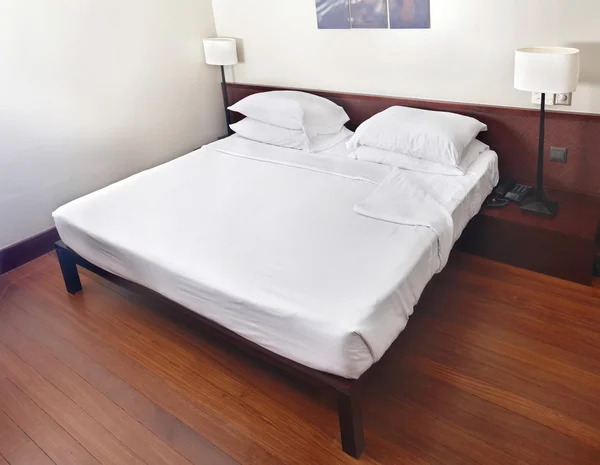 Łóżko i zagłówkiem w sypialni z Lampa. — Zdjęcie stockowe