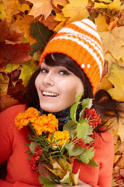 Meisje in herfst oranje hoed op blad groep met bloem. — Stockfoto