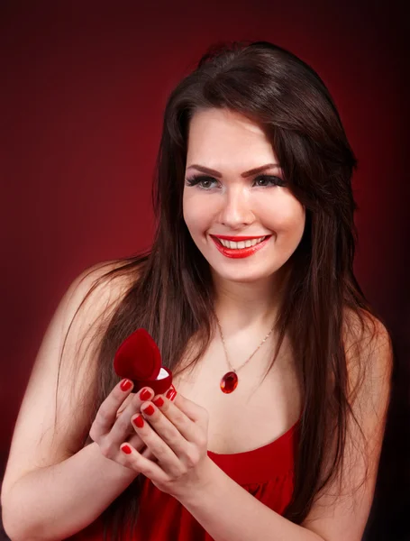Flicka med smycken box på röd bakgrund. — Stockfoto