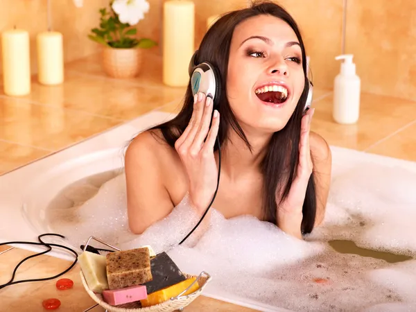 Mujer escuchando música en el baño —  Fotos de Stock