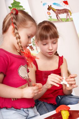 Kids mould plasticine in playroom.