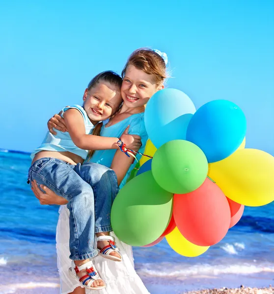 Niño jugando con globos en la playa — Foto de Stock