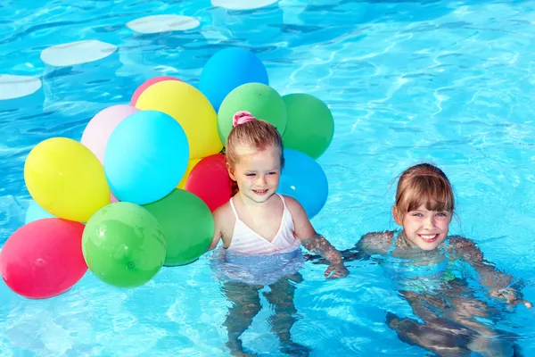 Kinderen spelen met ballonnen in zwembad. — Stockfoto