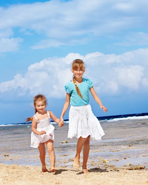 Дети держатся за руки, гуляя по пляжу . — стоковое фото