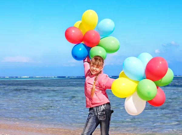 Ребенок играет с воздушными шарами на пляже — стоковое фото