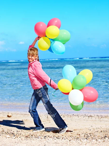 Kid playing with balloons at the beach — Stock Photo, Image