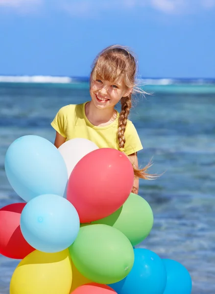 Kind spielt mit Luftballons am Strand — Stockfoto