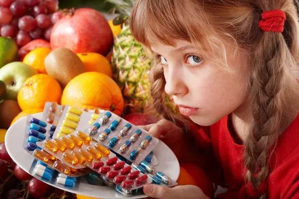 Child with fruit and vitamin pill. — Stock Photo, Image