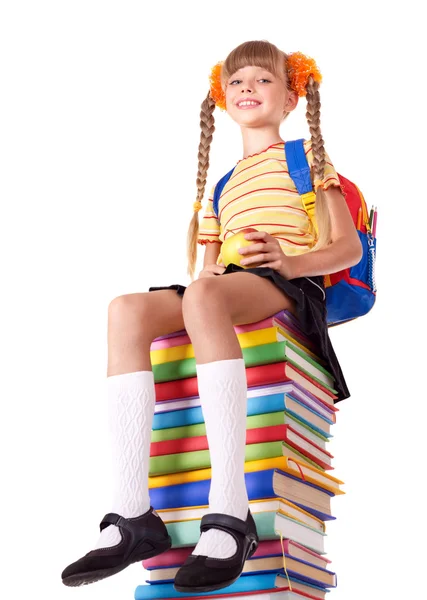 Školačka sedí na hromadě knih. — Stock fotografie