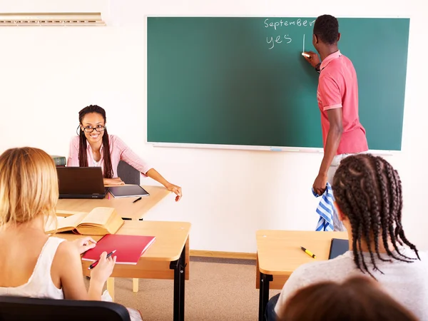 Estudante em sala de aula perto de quadro negro . — Fotografia de Stock