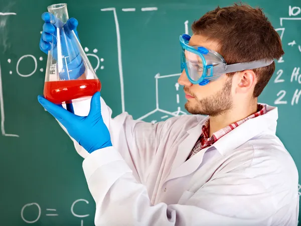 Student chemie muž s baňky. — Stock fotografie