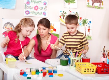 Children with teacher painting play room. clipart