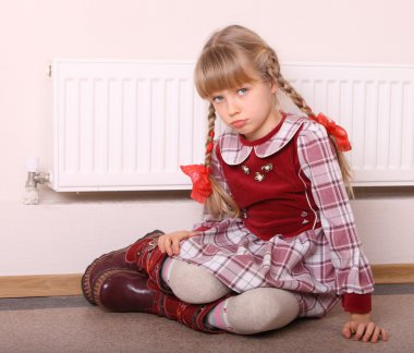 Girl warm near radiator. Crisis. clipart