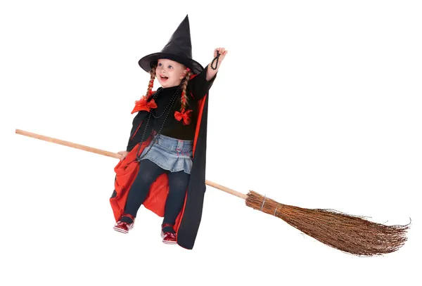 Kind in kostuum halloween heks vliegen op bezem. — Stockfoto