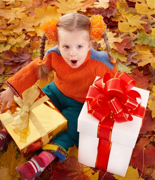Kind im Herbst orange Blätter und Geschenkbox. — Stockfoto
