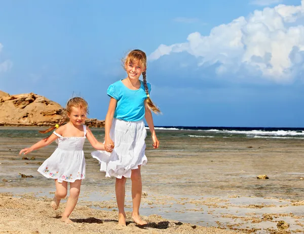 Niños tomados de la mano caminando por la playa . — Foto de Stock