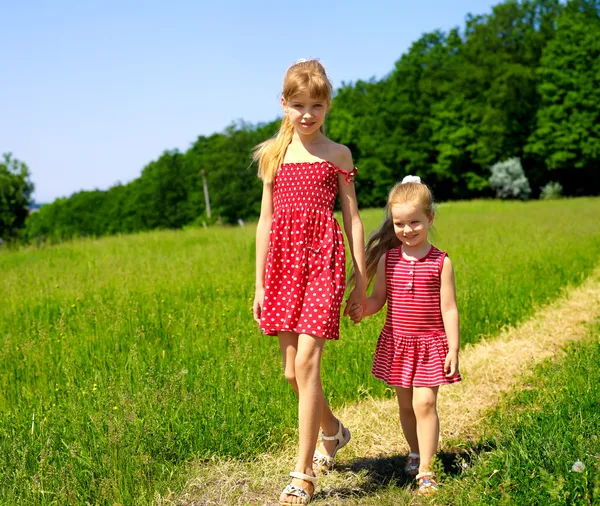 Niños corriendo a través de hierba verde al aire libre . — Foto de Stock