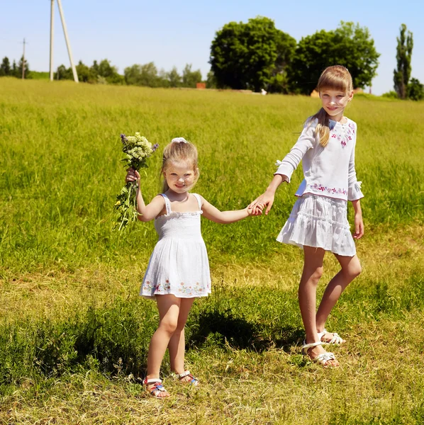 Kids running across green grass outdoor. — Stock Photo, Image