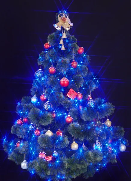 Julgran med ljus och blå stjärna. — Stockfoto