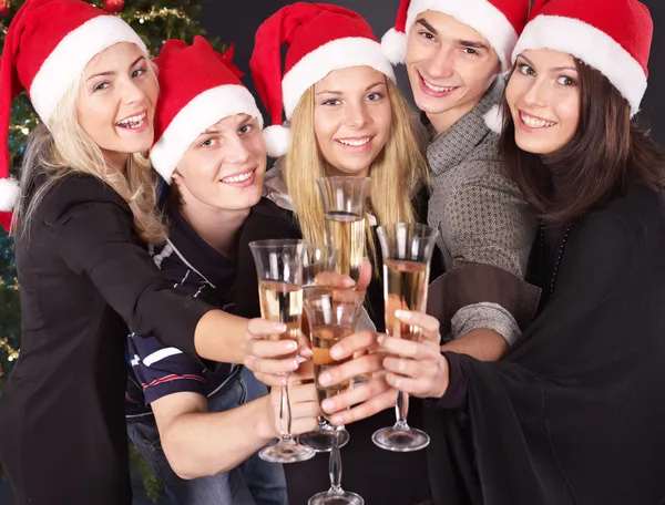 Groep jonge in Kerstman hoed bij nightclub. — Stockfoto
