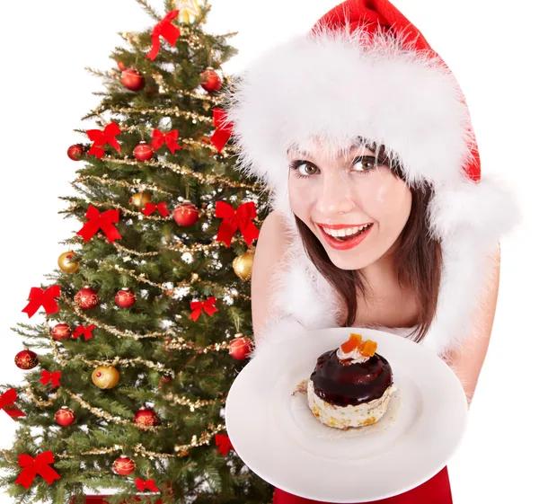 Дівчина в червоному капелюсі Санта їсть торт на тарілці . — стокове фото