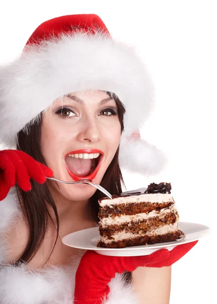 Meisje in Kerstman hoed eten taart op plaat. — Stockfoto