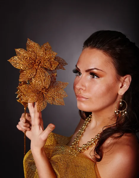 Młoda kobieta z złoty kwiat na szarym tle. — Zdjęcie stockowe