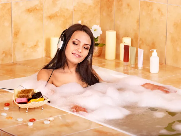 Mujer escuchando música en el baño — Foto de Stock