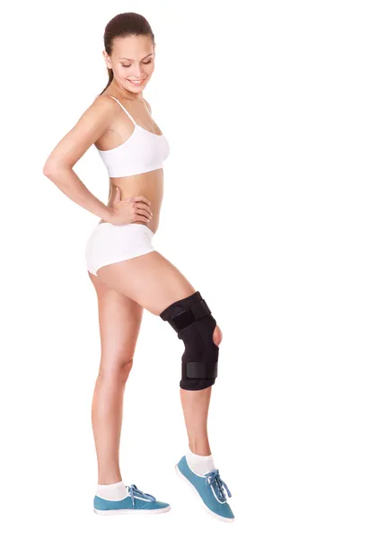 Girl with trauma of knee in brace. — Stock Photo, Image