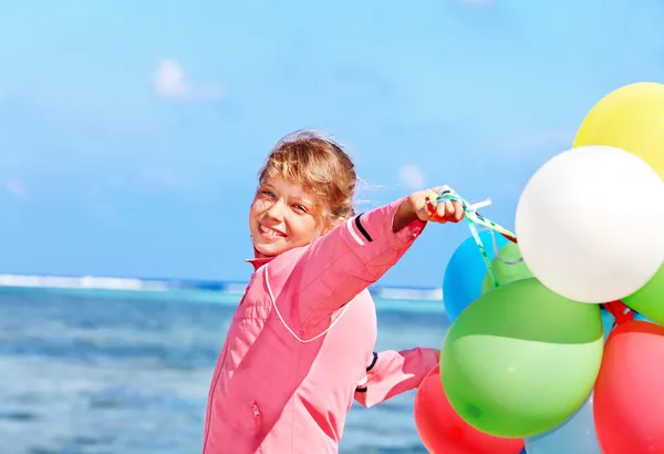 Criança brincando com balões na praia . — Fotografia de Stock