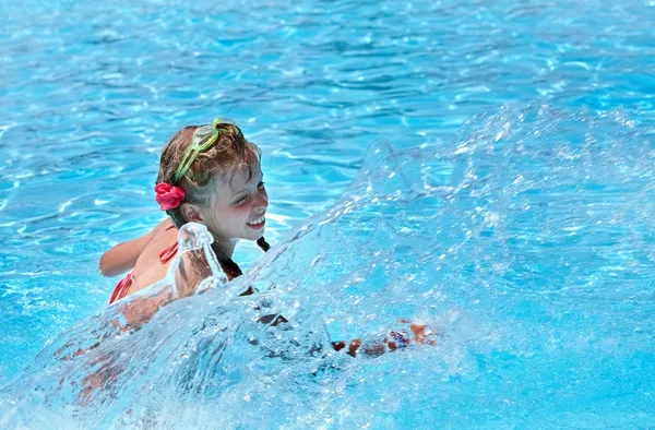 Girl with goggles and red bikini splashing in swimming pool. — Stock Photo, Image