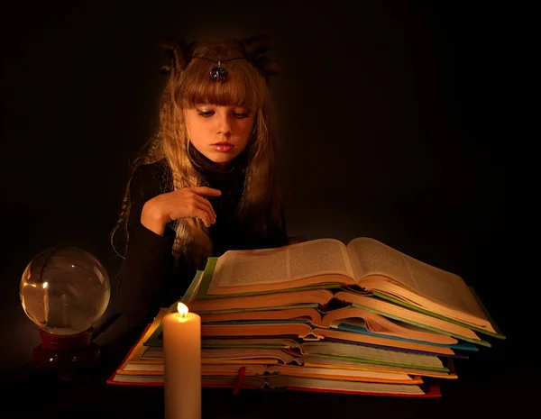 Dítě čtení kouzelné knihy na svíčku. — Stock fotografie