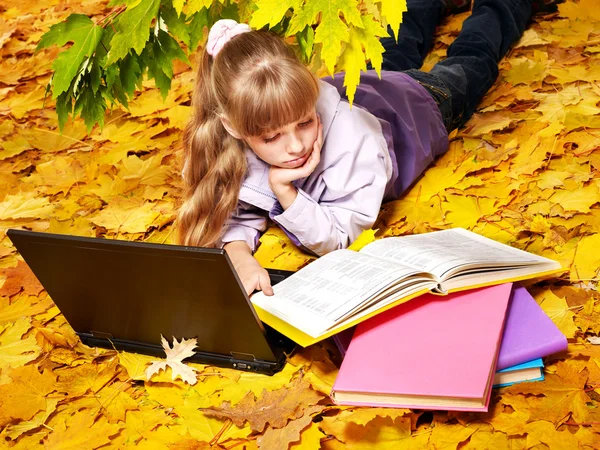 Dziecko w orange jesień liście z laptopa. — Zdjęcie stockowe