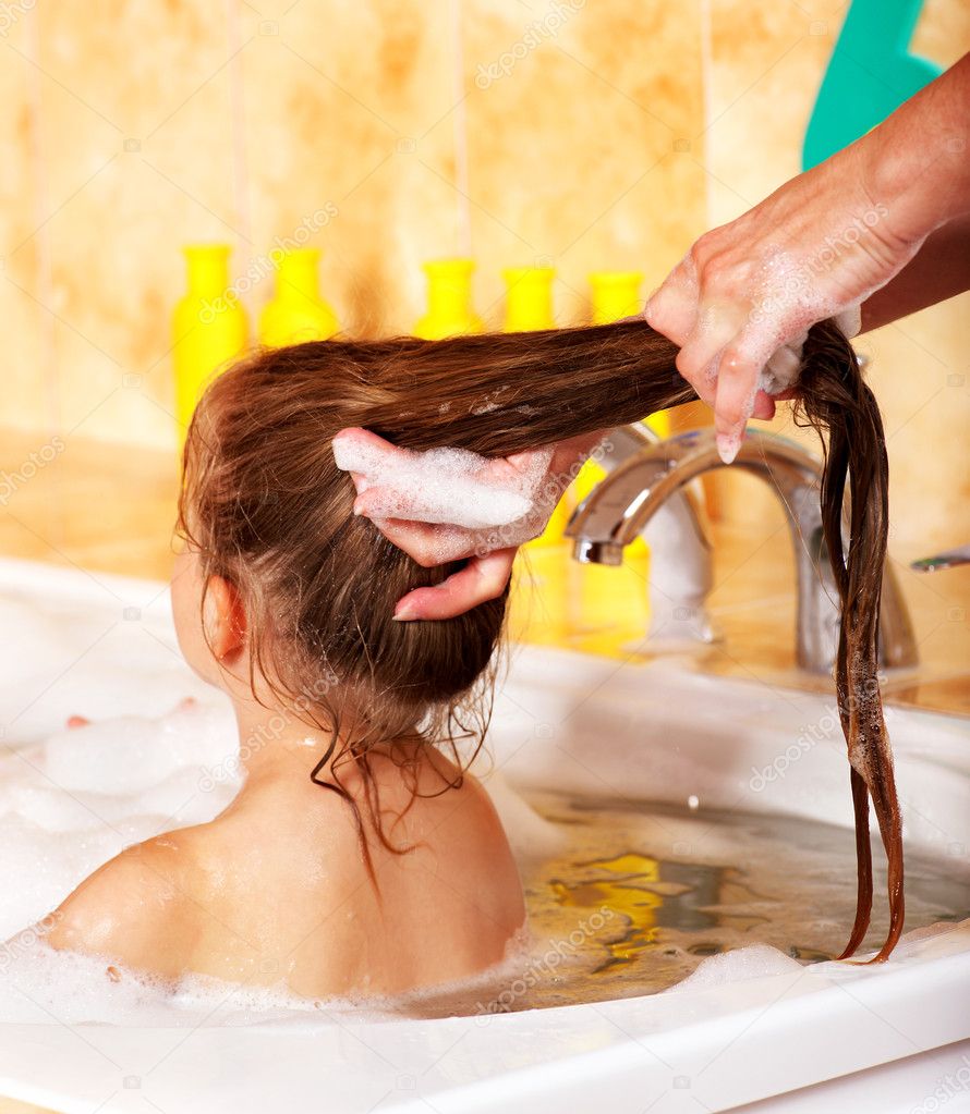 Kid washing hair by shampoo .
