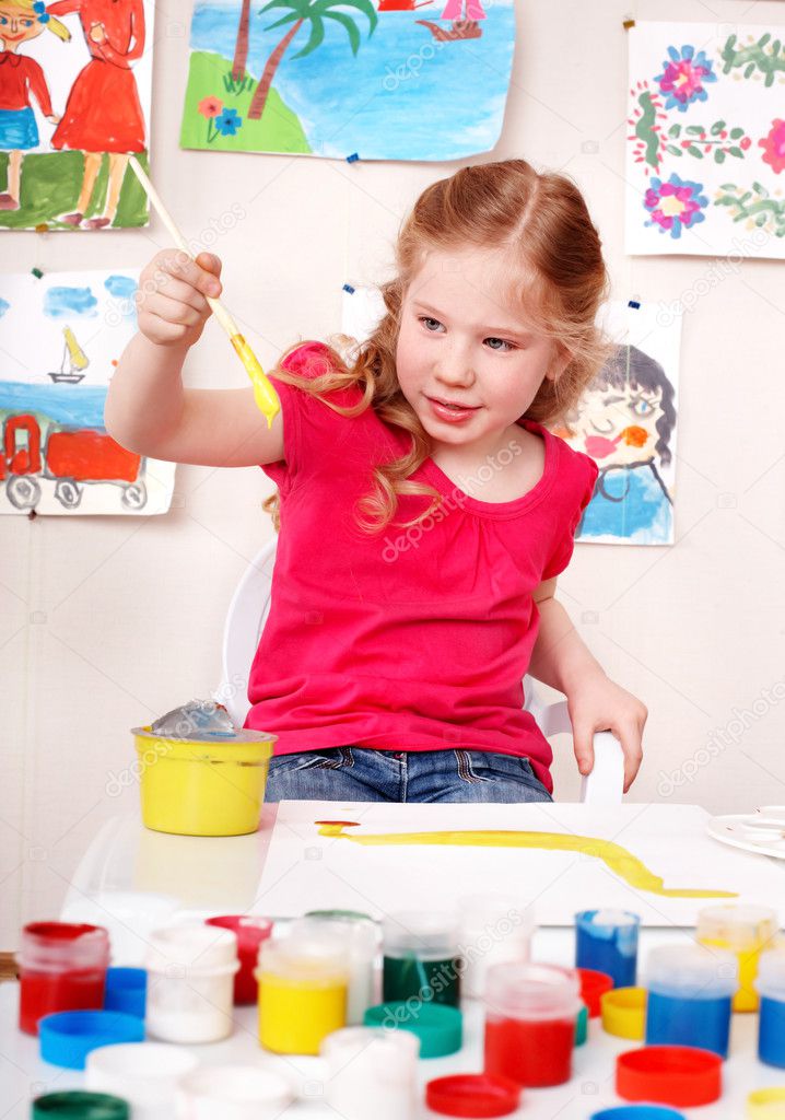 Child preschooler painting picture in play room.