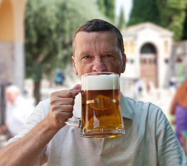 Stora liters glas öl i senior hand — Stockfoto