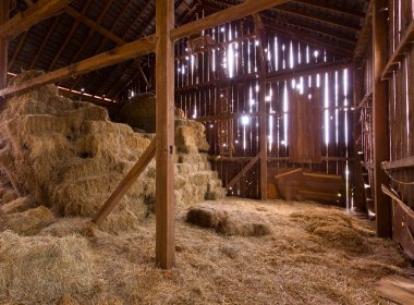 Interior of old barn with straw bales clipart