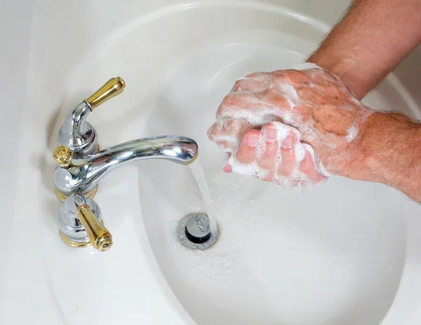 Старший мужчина моет руки с мылом — стоковое фото
