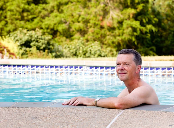 Senior man by edge of swimming pool — Stock Photo, Image