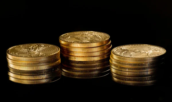 Макроизображение золотой орлиной монеты на стопке — стоковое фото