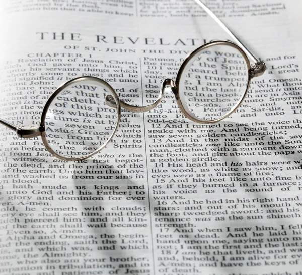 Antique reading glasses on page of bible — Stock Photo, Image
