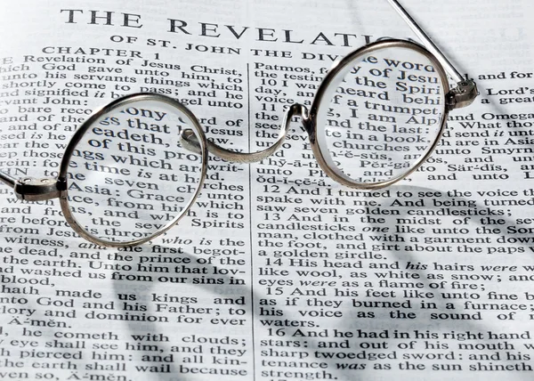 Antique reading glasses on page of bible — Stock Photo, Image