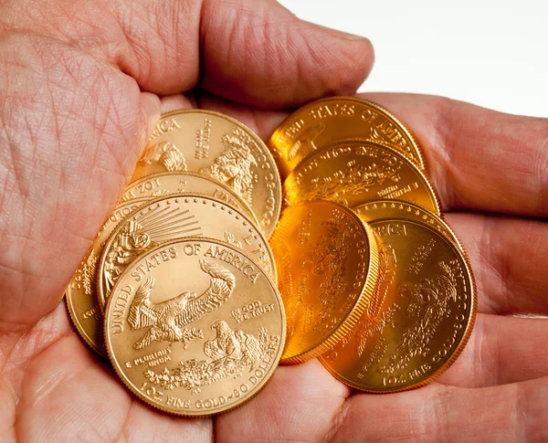 ゴールド コインのスタックを持っている手 — ストック写真