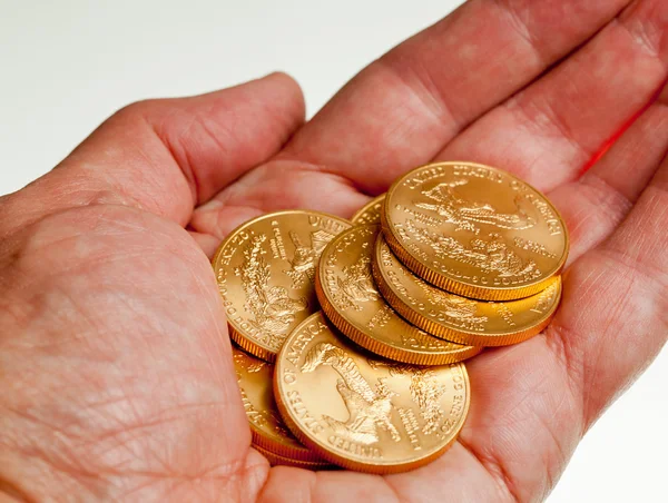 Pilha mão segurando de moedas de ouro — Fotografia de Stock