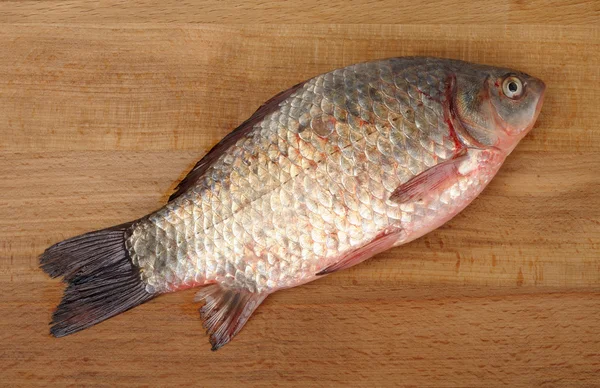 Crucian on a wooden background — Stock Photo, Image