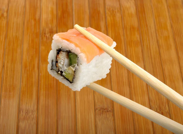 Σούσι στο ξύλινων chopsticks — Φωτογραφία Αρχείου