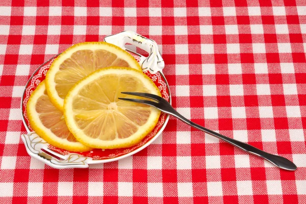 Egy tányérra egy villával citrom — Stock Fotó